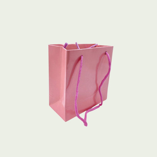 Pinkfarbene Papiertüte mit Seidenband